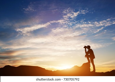 Man standing on rocks, looking through binoculars. Looking forward into the future. Sunset scenic sky. 3d illustration.