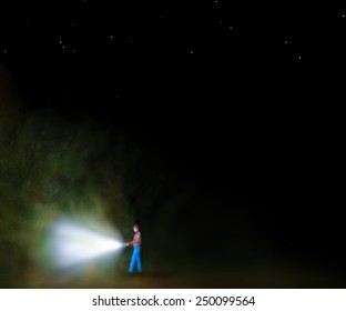 Man in woods at night with flashlight