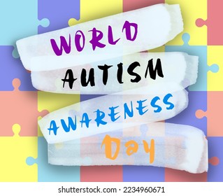 Many colorful puzzle pieces and text World Autism Awareness Day, top view - Powered by Shutterstock