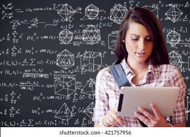 Maths against young focused student using a tablet computer