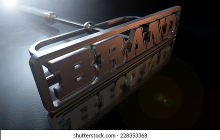 A Metal Cattle Brand With The Word Brand As The Marking Area On An Isolated Dark Backlit Surface And Background