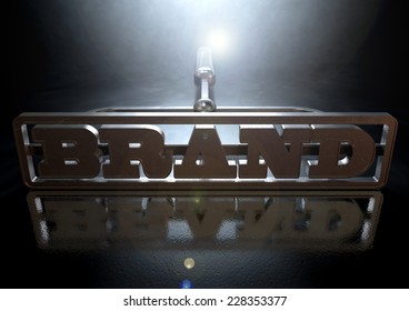 A Metal Cattle Brand With The Word Brand As The Marking Area On An Isolated Dark Backlit Surface And Background