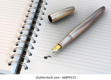 Metal Fountain Pen On Notebook With Ink Drop