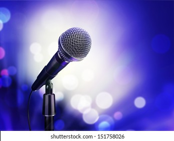 microphone on a blue background in the rays of searchlights
