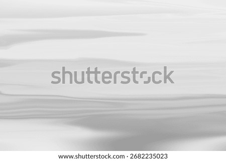 A minimalist abstract background featuring subtle gray waves on a white surface, providing a serene and elegant texture for various design applications and creative projects.