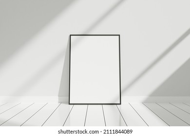 Minimalist and clean vertical black poster or photo frame mockup on the floor leaning against the room wall with shadow