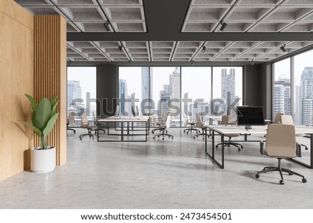 Minimalist office interior with pc computers on desks in row, concrete floor. Stylish workspace with panoramic window on Bangkok skyscrapers. 3D rendering