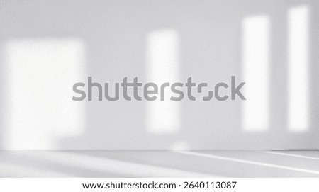 Minimalistic simple light pearl background for product presentation. Streaming sunlight and shadow from the window on perl white gray wall