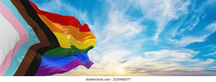 Minsk, Belarus - May, 2021: new Progress LGBTQ rainbow flag waving in wind at cloudy sky. Pride month. activism, community and freedom Concept. Freedom and love concept. Copy space. 3d illustration.