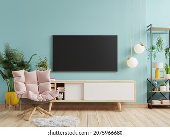 Mockup A TV Wall Mounted With Armchair In A Living Room With A Blue Wall.3d Rendering