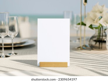 Mockup white blank space card, for greeting, table number, wedding invitation template on wedding table setting background. with clipping path. 3D rendering - Powered by Shutterstock