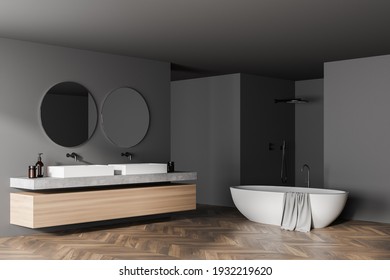 Modern Bathroom Interior With Double Sink, Shower And White Bathtub, In Eco Minimalist Style With Brown Wooden Parquet Floor. And Two Round Mirrors. No People. 3D Rendering