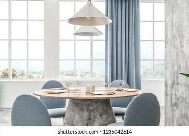 Modern cafe interior with white and concrete walls, concrete floor and round wooden table with blue chairs. Blue curtains on the windows. 3d rendering - Powered by Shutterstock