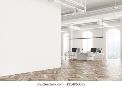 Modern Company Office Interior With White Computer Tables, Arched Windows And A Wooden Floor. Concept Of Interior Design. Angle View. Blank Advertisement Wall. 3d Rendering Mock Up.