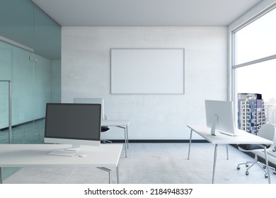 Modern Concrete Coworking Office Interior With Empty Computer Screen And Mock Up Poster On Wall, Window With City View And Daylight. 3D Rendering