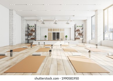 Modern concrete yoga gym interior with equipment, daylight and wooden flooring. Healthy lifestyle concept. 3D Rendering - Powered by Shutterstock