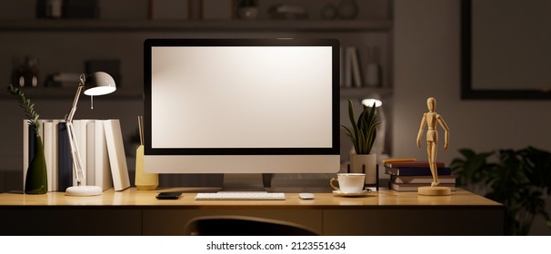 Modern Dark Private Office Room Or Home Office Workspace At Night With Pc Desktop Computer White Screen Mockup And Supplies On The Table Under Light From Lamp. 3d Rendering, 3d Illustration