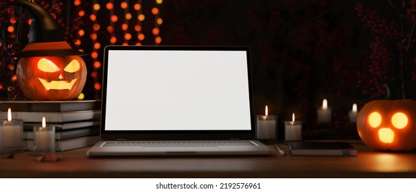 Modern Dark Working Space Or Office Desk With Halloween Decor, Laptop White Screen Mockup, Candles, Spooky Pumpkin Lamps. Close-up Image. 3d Rendering, 3d Illustration