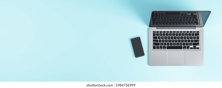 Modern Grey Laptop With Black Keyboard And Cell Phone On Blank Light Blue Background. Mock Up, 3D Render