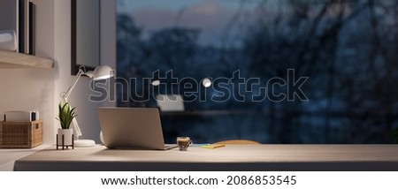 Modern home office room with laptop computer and copy space on working desk over blurred outdoor view at night in the background. 3d rendering, 3d illustration 商業照片 © 