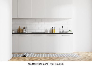 Modern Kitchen Interior With White Brick Walls, White Countertops And A Wooden Floor With A Rag On It. 3d Rendering Mock Up