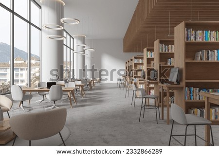 Modern library interior with table and chairs in row, bookshelf with pc computer on grey concrete floor. Stylish learning workplace in public loft with modern furniture. 3D rendering