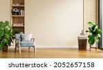 Modern minimalist interior with an armchair on empty cream color wall background.3D rendering