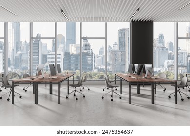 Modern office interior with pc computers on desks in row, light concrete floor. Cozy coworking space with panoramic window on Bangkok skyscrapers. 3D rendering