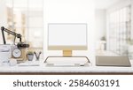 A modern podcaster office features a computer with a white screen mockup, a graphic tablet, a microphone, and decorative items on a desk. 3d render, 3d illustration