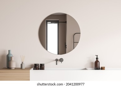 Modernes Design mit Holzaussehen und weißen Keramikwaschbecken sowie einem eleganten, runden Spiegel an der beigen Wand des Duschraums. Ein Konzept der Innenarchitektur Trends. 3D-Rendering