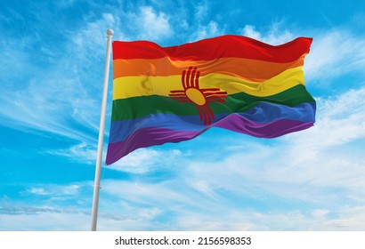 modified flag of New Mexico state, USA with rainbow LGBT pride flag at cloudy sky background on sunset, panoramic view. copy space for wide banner. 3d illustration