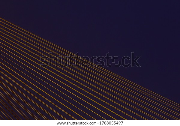 Mordern cable stayed bridge with illuminated\
cables. Abstract detail\
photo.