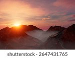 A mountain range with a sun setting behind it. The sky is orange and pink