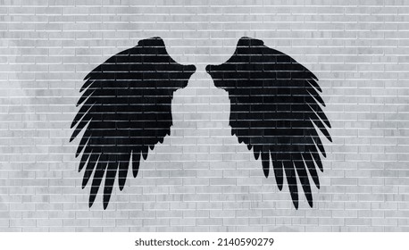 Mural Or Graffiti Art. Black Angel Wings On Old Brick Wall In Grey Tones. Perfect Background For Photo Studio Or Wallpaper For An Industrial Loft. 