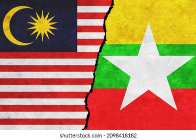 Myanmar and Malaysia painted flags on a wall with a crack. Myanmar and Malaysia conflict. Malaysia and Myanmar flags together. Myanmar vs Malaysia