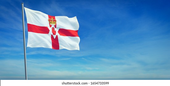 The National flag of Northern Ireland blowing in the wind in front of a clear blue sky. 3d illustration.