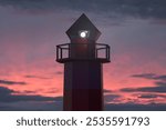 The nautical lighthouse tower against the backdrop of a stunning sunset sky. 3d rendering