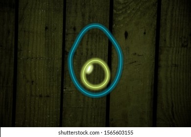 neon light with avocado shape on dark background