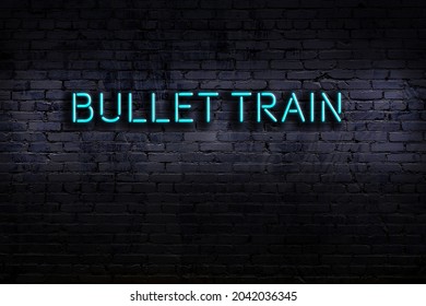 Neon Sign With Inscription Bullet Train Against Brick Wall. Night View