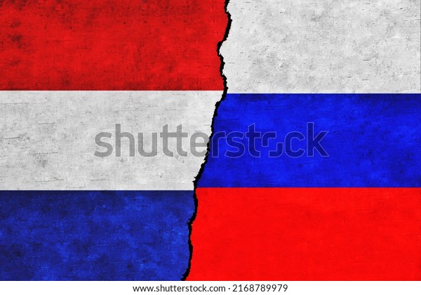 Netherlands and Russia painted flags on a wall\
with a crack. Netherlands and Russia relations. Russia and\
Netherlands flags\
together