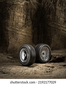 A New Car Wheel Standing On A Rocky Stage. A Car Tire Standing Upright And Sideways On Rocky Ground In Front Of A Natural Cliff. 3d Rendering, No People