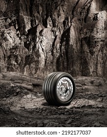 A New Car Wheel Standing On A Rocky Stage. A Car Tire Standing Upright And Sideways On Rocky Ground In Front Of A Natural Cliff. 3d Rendering, No People