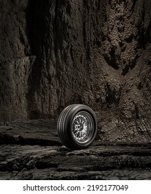 A New Car Wheel Standing On A Rocky Stage. A Car Tire Standing Upright And Sideways On Rocky Ground In Front Of A Natural Cliff. 3d Rendering, No People