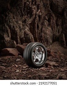 A New Car Wheel Standing On A Rocky Stage. A Car Tire Standing Upright And Sideways On Rocky Ground In Front Of A Natural Cliff. 3d Rendering, No People