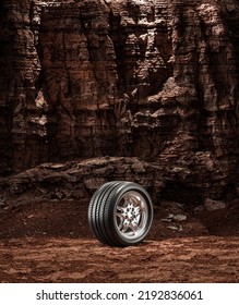 A New Car Wheel Standing On A Rocky Stage. A Car Tire Standing Upright And Sideways On Rocky Ground In Front Of A Natural Cliff. 3d Rendering, No People