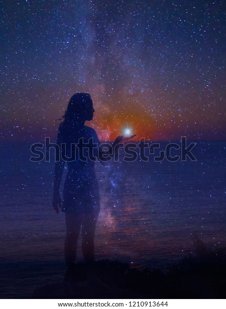 星が満ちた夜空と 星を手にした立っている女の子のシルエット 人間と宇宙の一体性 のイラスト素材