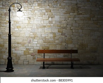 Night view of the illuminated brick wall with old fashioned street light and bench