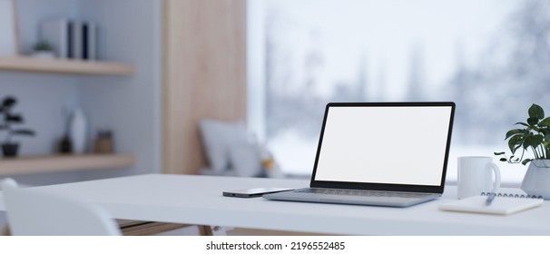Notebook Laptop White Screen Mockup And Stuff On White Tabletop Over Blurred Modern Home Living Room In Background. 3d Rendering, 3d Illustration