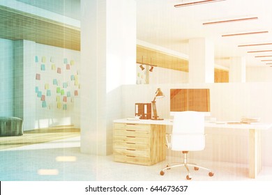 Office interior with a computer standing on a desk, light wooden floor, columns and a white wall with sticky notes. 3d rendering, mock up, toned image