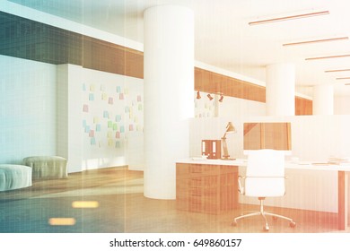 Office interior with a computer standing on a desk, dark wooden floor, round columns and a white wall with sticky notes. 3d rendering, mock up, toned image